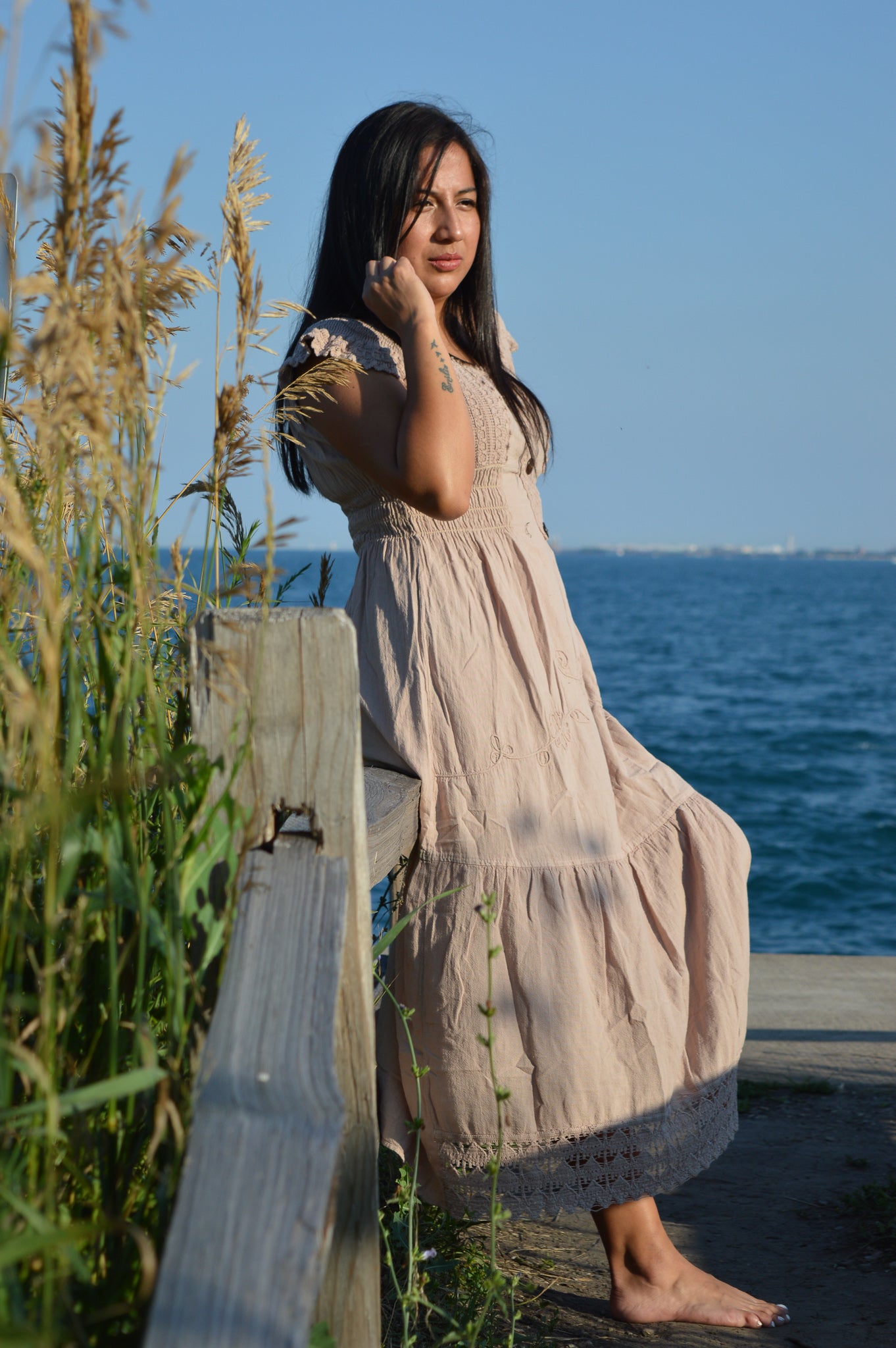 Woman wearing beige cotton dress at chicago lake front.