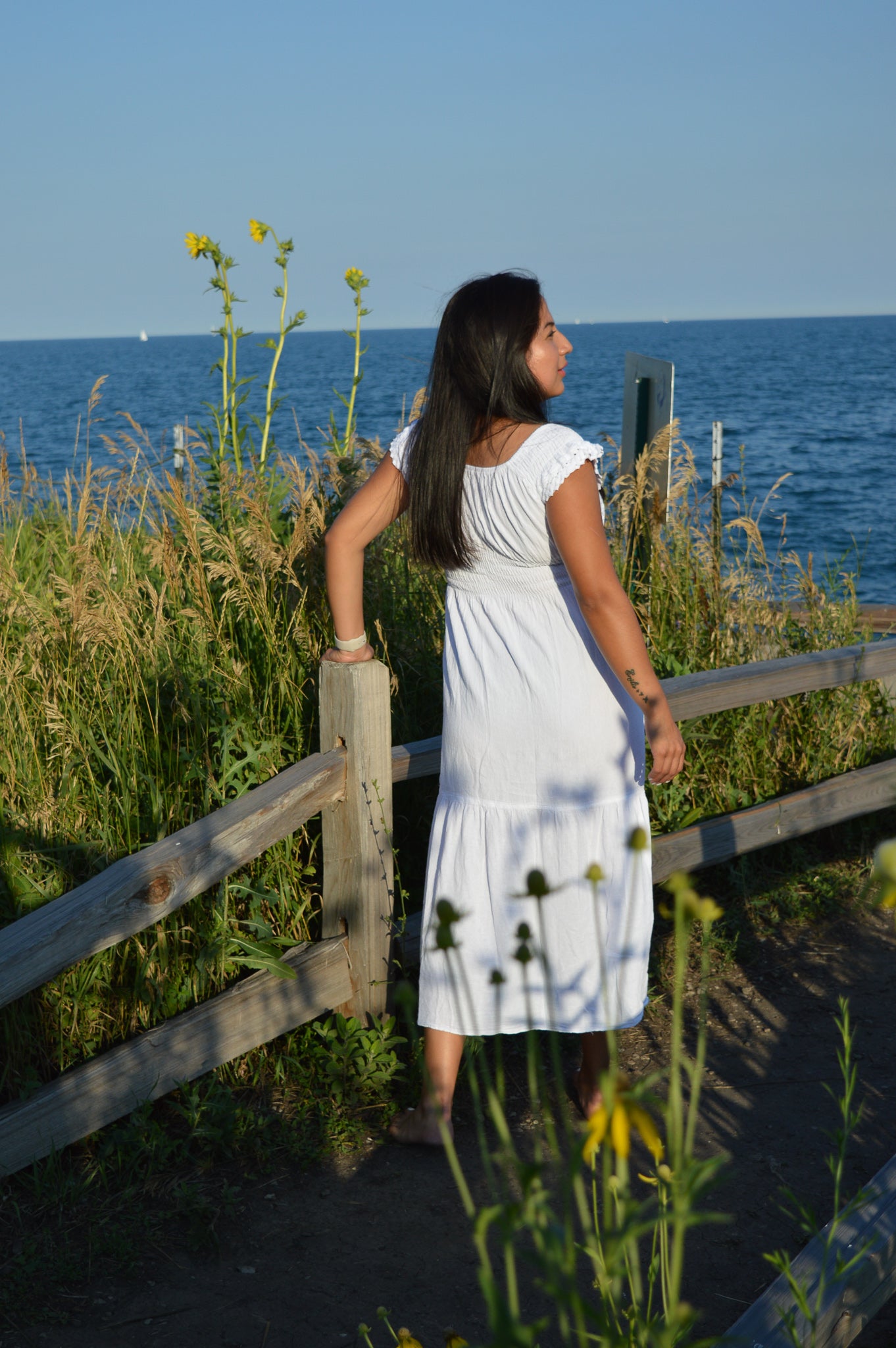 Woman wearing white cotton dresss at chicago lake front. Sunny