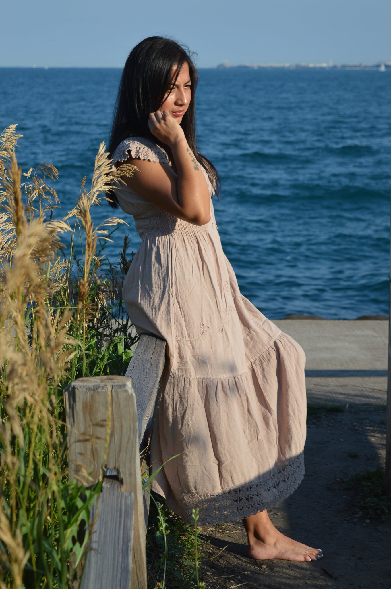 Woman wearing beige cotton dress at chicago lake front.