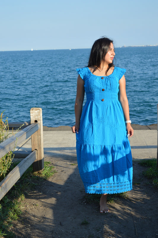 Woman wearing blue cotton dresss at chicago lake front. Sunny. Head turned left